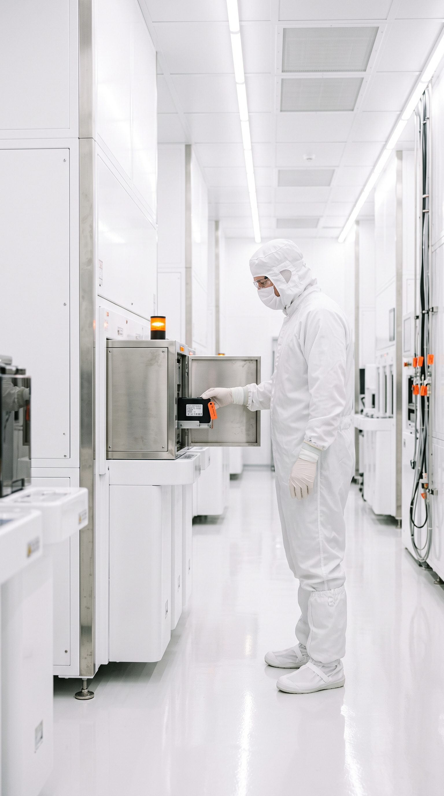 Engineer in a cleanroom suit inside a secure, isolated facility
